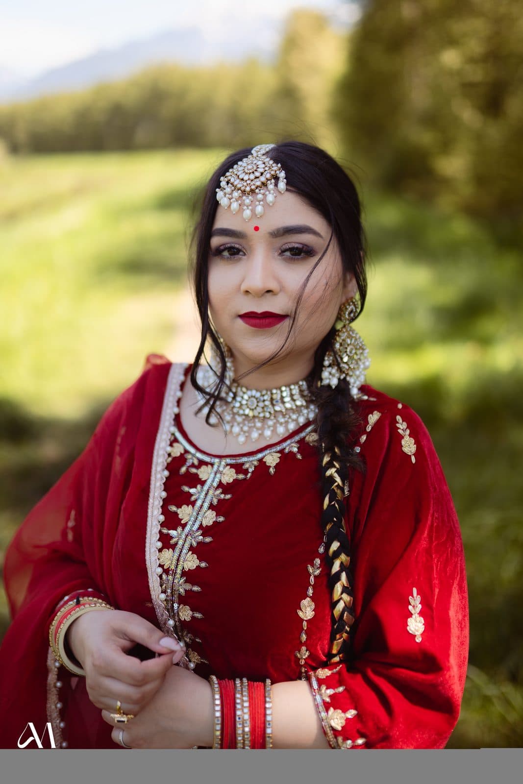 Bridal makeup with tikka and red embroidered outfit photographed outdoors by 902 Beauty Bar, Dartmouth NS