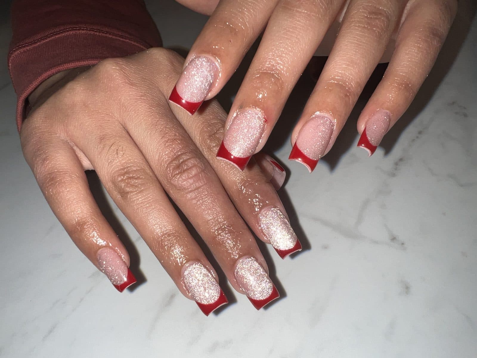 Red French tips with glitter accents on square nails, marble background by 902 Beauty Bar, Dartmouth NS