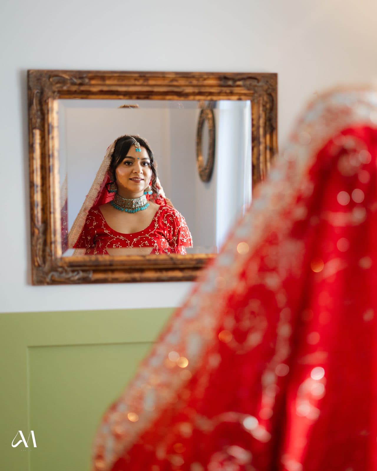 Bride reflected in a gold framed mirror wearing a red dupatta by 902 Beauty Bar, Dartmouth NS
